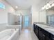 Primary bath with double vanity, granite countertops, soaking tub, and glass shower at 3273 Lilac Way, Davenport, FL 33897