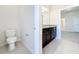 This bathroom features a toilet and a vanity with a granite countertop at 3273 Lilac Way, Davenport, FL 33897