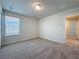 A well lit bedroom has neutral walls and carpeting and a window at 3273 Lilac Way, Davenport, FL 33897
