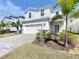 Inviting home exterior showcasing a well-kept lawn, mature landscaping, and a spacious two-car garage at 3273 Lilac Way, Davenport, FL 33897