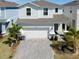 Charming two-story home featuring manicured landscaping, a paved driveway, and a two-car garage at 3273 Lilac Way, Davenport, FL 33897