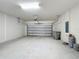View of an empty two car garage with gray door at 3273 Lilac Way, Davenport, FL 33897