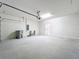 View of a spacious two car garage with lighting and door to interior of home at 3273 Lilac Way, Davenport, FL 33897