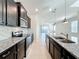 Modern kitchen with granite countertops, stainless steel appliances, and view into living area at 3273 Lilac Way, Davenport, FL 33897