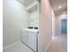 Laundry room with white washer and dryer near hallway at 3273 Lilac Way, Davenport, FL 33897