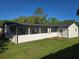 Expansive backyard featuring a screened in lanai, white exterior, and lush greenery for outdoor enjoyment at 383 Floral Dr, Winter Garden, FL 34787