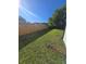 Fenced backyard with vibrant green grass and mature trees, perfect for relaxing and entertaining outdoors at 383 Floral Dr, Winter Garden, FL 34787