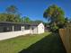 Beautiful backyard featuring a new wooden fence, grassy area, and screened lanai for serene outdoor enjoyment at 383 Floral Dr, Winter Garden, FL 34787