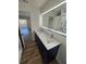 Stylish bathroom features double sinks, illuminated mirror, and spacious, updated walk-in shower at 383 Floral Dr, Winter Garden, FL 34787