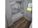 Updated bathroom features a shower and tub with marble tile and wood-look flooring at 383 Floral Dr, Winter Garden, FL 34787