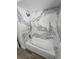 White tub and marble tile shower surround features a rainfall shower head in the updated bathroom at 383 Floral Dr, Winter Garden, FL 34787
