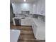 Modern kitchen with white cabinetry, stone countertops, stainless steel appliances, and stylish backsplash at 383 Floral Dr, Winter Garden, FL 34787