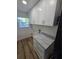 Convenient laundry room with white cabinets, gray countertops, and wood-look floors at 383 Floral Dr, Winter Garden, FL 34787