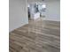 An open-concept living space is displayed highlighting the new wood-look flooring and an adjacent modern kitchen at 383 Floral Dr, Winter Garden, FL 34787
