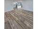 Here's another view of the open-concept living room showcasing the wood-look flooring and modern kitchen beyond at 383 Floral Dr, Winter Garden, FL 34787