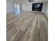 Large living room with modern wood-look floors, ceiling fan, and a built-in fireplace media center for cozy living at 383 Floral Dr, Winter Garden, FL 34787