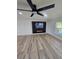 Modern living room featuring wood-look floors, a ceiling fan, and a built-in media center for entertainment at 383 Floral Dr, Winter Garden, FL 34787