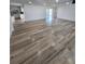 This is a spacious living room featuring an open floor plan, wood-look flooring, and access to the kitchen at 383 Floral Dr, Winter Garden, FL 34787