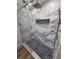 Elegant shower featuring marble tile surround, built-in niche, and hexagon tile base at 383 Floral Dr, Winter Garden, FL 34787