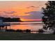 Sunset photo with vivid orange and yellow colors reflecting on a calm lake surrounded by trees and plant life at 383 Floral Dr, Winter Garden, FL 34787