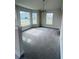 Bright living room featuring three large windows, neutral gray carpet, and modern light fixture at 4236 Sagefield Dr., St Cloud, FL 34773