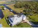Aerial view of a home featuring lush green landscaping, an in-ground pool, and a covered outdoor space near a canal at 4240 Lake Harney Cir, Geneva, FL 32732