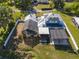 An aerial view showcasing a home with a screened-in pool, pergola, and solar panels, surrounded by a fenced yard at 4240 Lake Harney Cir, Geneva, FL 32732