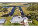 An aerial view of a property with a pristine lawn, in-ground pool, and canal frontage, showcasing beautiful waterfront living at 4240 Lake Harney Cir, Geneva, FL 32732