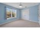 This bedroom has a ceiling fan, a large window, and a double door closet at 4240 Lake Harney Cir, Geneva, FL 32732