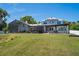 Expansive backyard with a screened pool, porch swing, pergola covered patio, and a well-maintained lawn at 4240 Lake Harney Cir, Geneva, FL 32732