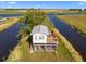 Elevated home with a second-story deck surrounded by water, providing unique water views at 4240 Lake Harney Cir, Geneva, FL 32732