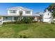 Charming two-story home featuring a lush green lawn and beautifully landscaped front yard with meticulous shrubbery at 4240 Lake Harney Cir, Geneva, FL 32732