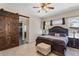 Bedroom with wooden sliding door, dark furniture, ceiling fan, and views of the window at 4240 Lake Harney Cir, Geneva, FL 32732