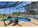 Screened pool area with a waterfall feature, lounge chairs, and scenic waterfront views at 4240 Lake Harney Cir, Geneva, FL 32732