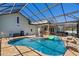 Large backyard pool with a full screen enclosure, outdoor kitchen, and water feature at 4240 Lake Harney Cir, Geneva, FL 32732
