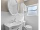 All-white bathroom features a pedestal sink, medicine cabinet, and window providing natural light at 4321 Summer Ln, Orlando, FL 32804