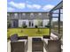 Backyard patio with dark wicker furniture, green lawn, and a view of the two-story home at 4839 Jackstaff Way, Oviedo, FL 32765