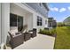 Backyard patio with dark wicker furniture, green lawn, and a view of the two-story home at 4839 Jackstaff Way, Oviedo, FL 32765