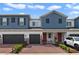 Charming exterior view of two-story townhomes with brick driveway and gray garages at 4839 Jackstaff Way, Oviedo, FL 32765