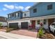 Charming exterior view of two-story townhomes with brick driveway and gray garages at 4839 Jackstaff Way, Oviedo, FL 32765