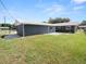 Large, grassy backyard featuring a dark gray house exterior with white trim and a chain-link fence at 5134 Harvard W St, Lakeland, FL 33810