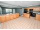 Open kitchen featuring wooden cabinetry, black appliances and an island with breakfast bar, great for entertaining at 5134 Harvard W St, Lakeland, FL 33810