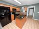 This modern kitchen boasts wood cabinetry, an island and black appliances for a sleek and functional space at 5134 Harvard W St, Lakeland, FL 33810