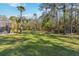 Lush green backyard with tall trees, offering privacy and shade at 5200 Carson St, St Cloud, FL 34771
