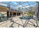 Screened-in pool area with ample seating, a grill, and a waterfall feature at 5200 Carson St, St Cloud, FL 34771