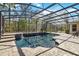 Covered pool with brick surround, waterfall feature, and screened enclosure for bug-free outdoor enjoyment at 5200 Carson St, St Cloud, FL 34771