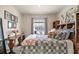 Comfortable bedroom featuring a patterned bedspread, side table with flowers, and a view to the street at 5367 Pinecone Ct, Wildwood, FL 34785
