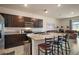 Modern kitchen with stainless steel appliances, kitchen island, and bar stool seating at 5367 Pinecone Ct, Wildwood, FL 34785