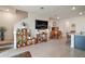 Inviting living room with tiled floors, staircase, mounted television, and dining area in background at 5367 Pinecone Ct, Wildwood, FL 34785