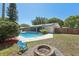 View of the in-ground pool, screened lanai, and fire pit in the lushly landscaped backyard at 5441 Justine Way, Winter Park, FL 32792